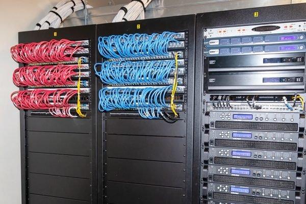 a rack of servers with many different colored wires attached to them